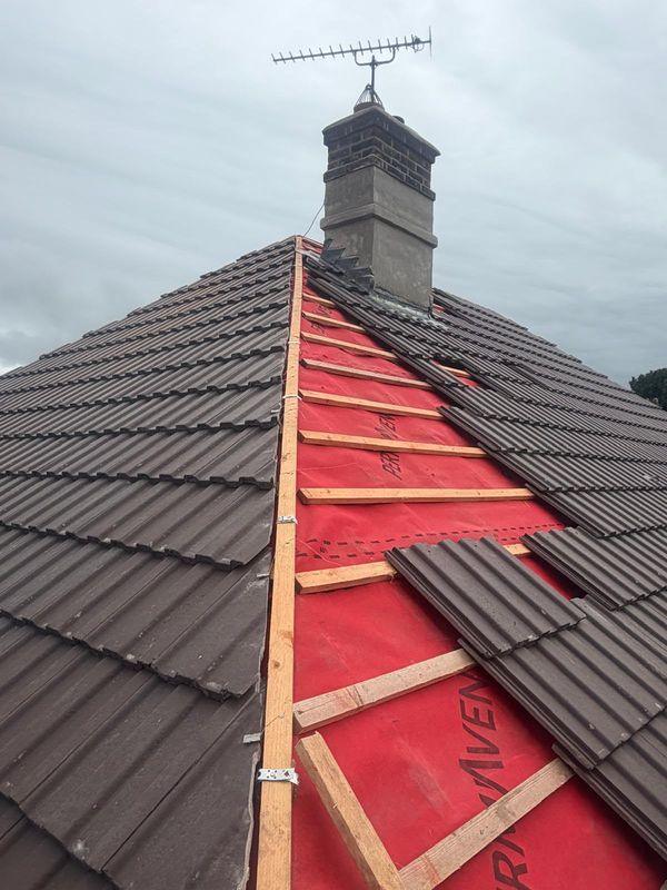 Roof half tiled over red membrane